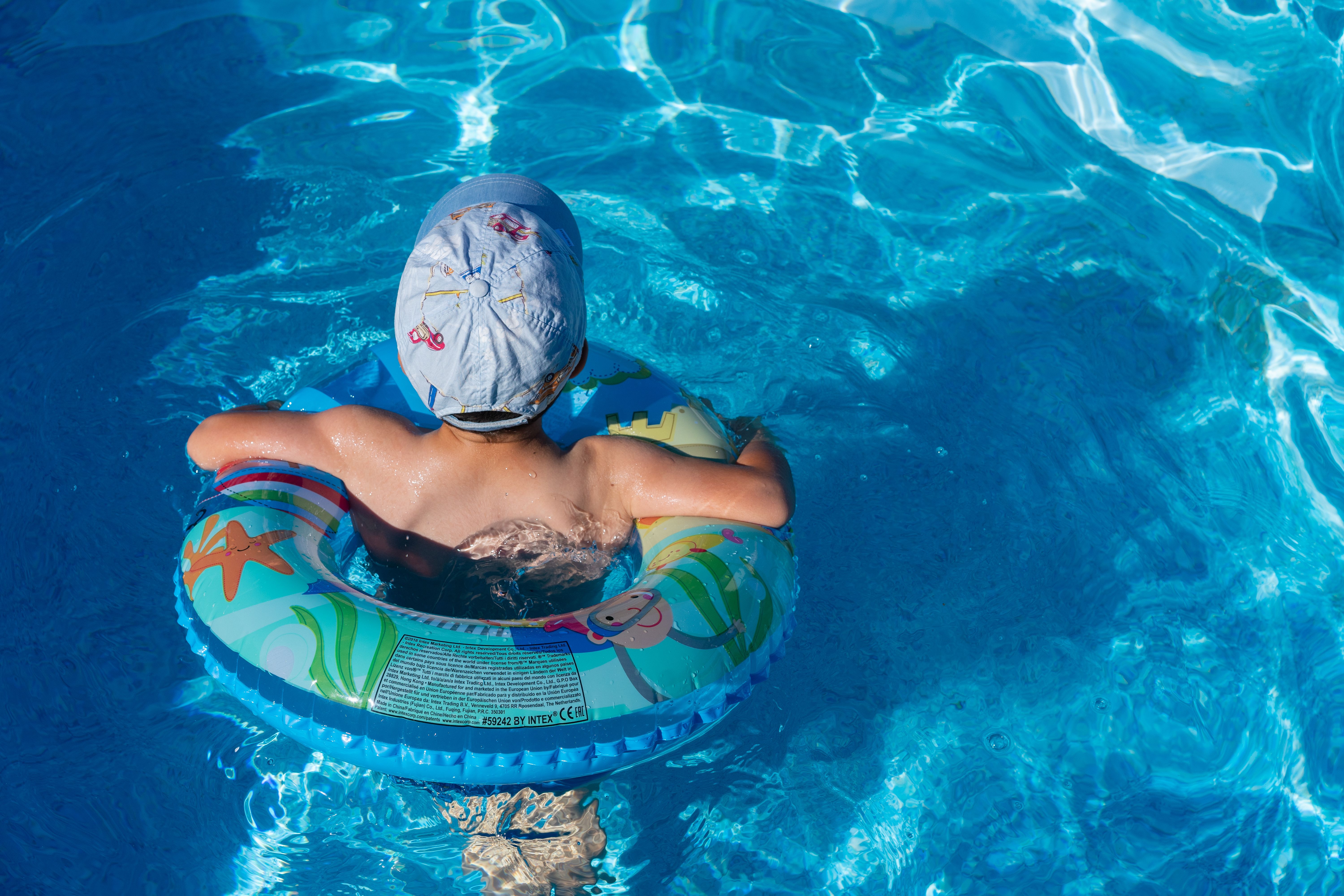 young child floating in a tube in a pool